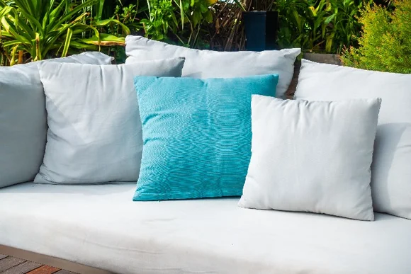 Gartenmöbel mit weißen und türkisen Kissen